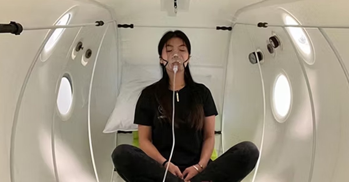 ผู้หญิงกำลังผ่อนคลายในห้อง Hyperbaric Oxygen พร้อมหายใจเอาออกซิเจนบริสุทธิ์